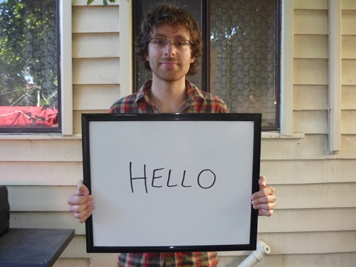Man holding sign saying hello