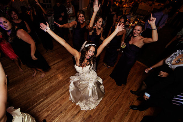When the dancing started I decided I wanted something different. I mounted a 5D Mark III on a monopod with 14mm lens. a flash was mounted on the camera with the head aimed at the ceiling for bounce. Using a remote release, I got the bride's attention and waited for her reaction, firing when I saw it. 