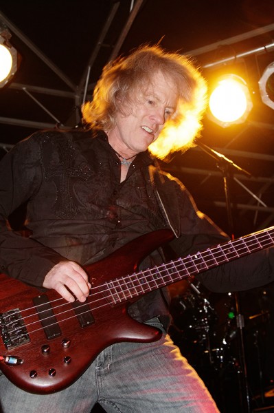This shot was early in the show, and I was experimenting with flash for my exposures. I used the built-in flash on the EOS 7D, and set the flash exposure compensation to -1 so as not to overpower the ambient. The result was good fill on his face, while the stage lighting created a nice backlight. The slower shutter speed of 1/100 allowed some motion blur in the hair, but that adds to the energy of the image. ISO was only 800 here, as it was the first song and I was still experimenting.