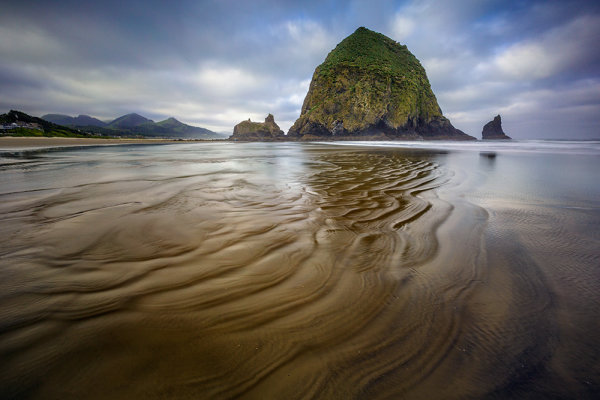 Wind and Water carved up the sand on the beach, creating a great foreground to use for this shot. EOS 5D Mark III, EF 16-35 f/2.8L II. Exposure was 4 seconds, f/16, ISO 100.  I used a 3 stop, soft edged graduated ND filter to help darken the sky, and a 6 stop ND filter to slow down my exposure. 