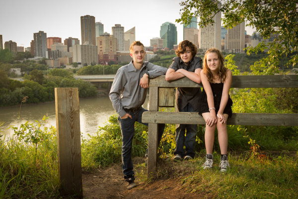 This was done just before sunset. The sun is coming just over their shoulders on the left. I used a flash in an umbrella also to the left to add light to their faces, without it they'd be in shadow.