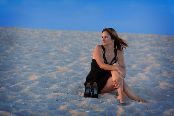 This was one of the last shots of the day. The beach was nearly empty and I wanted to use the texture of the sand, the deep blue of the sky, and the red glow of the sun to create a graphically strong image. I positioned her so that if she turned her head her face would be lit by the sun and the sun would create a rim of light on her side. EOS 5D Mark III with EF 85mm f/1.2L II. 1/320, f/2.8, ISO 100.