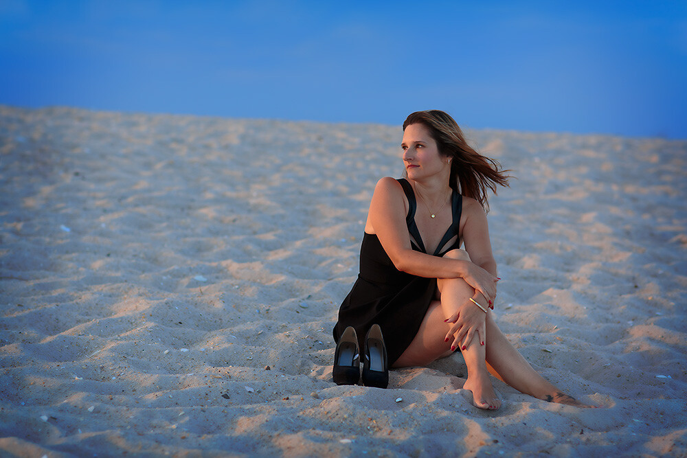 This was one of the last shots of the day. The beach was nearly empty and I wanted to use the texture of the sand, the deep blue of the sky, and the red glow of the sun to create a graphically strong image. I positioned her so that if she turned her head her face would be lit by the sun and the sun would create a rim of light on her side. EOS 5D Mark III with EF 85mm f/1.2L II. 1/320, f/2.8, ISO 100.