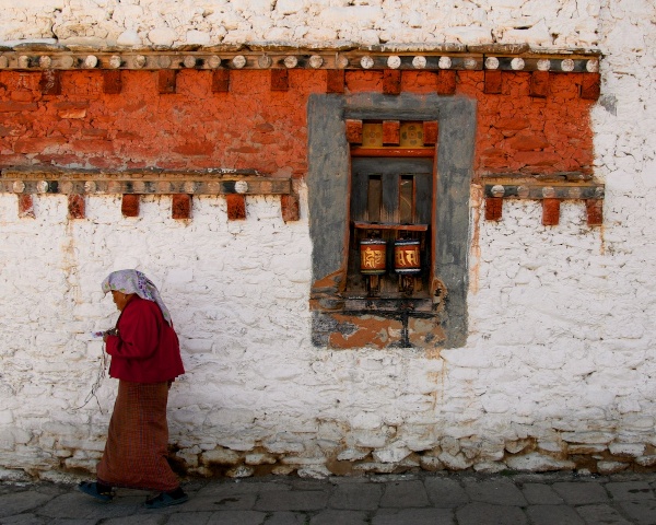 Travel Photography Tips - Everyday Life Woman Spinning Prayer Wheels at 7th Century Monastery Bumthang Bhutan Copyright 2013 Ralph Velasco