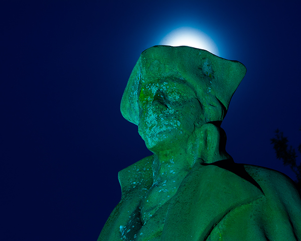 In this image shot at night the white balance was changed to Tungsten, which causes the monument to have a teal color. The glow above the head was created by the moon glow.