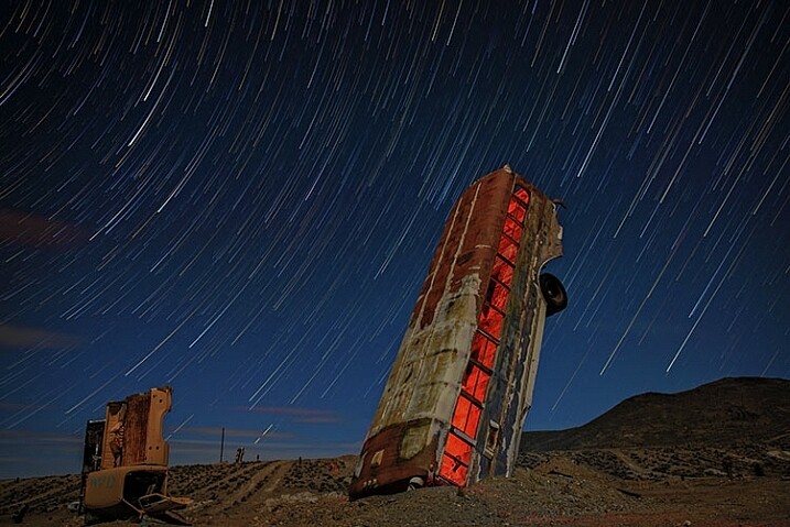 This image was created by merging 116 separate exposures in StarStax software in comet mode. Each exposure was 30 seconds, ISO 400 at f/2.8. A red LED flashlight was shone inside the bus for the first exposure. 