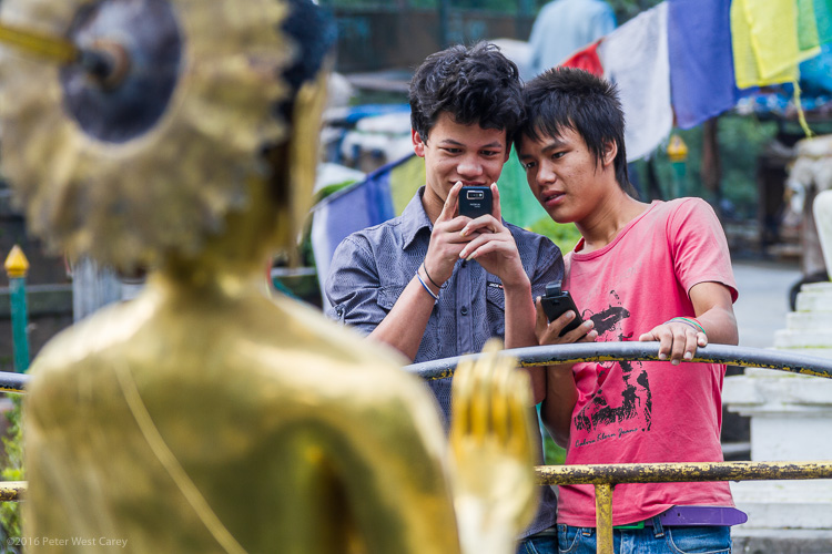 Boys photographing statue of buddha - Nepal