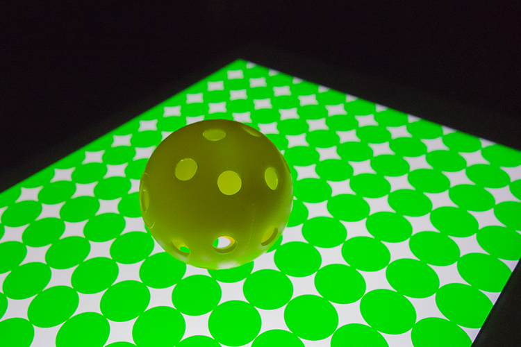 yellow-ball-on-green-circles-background