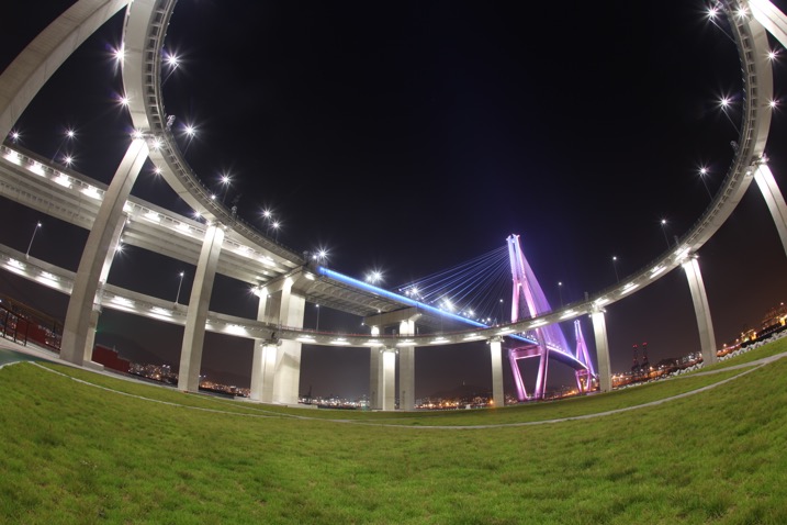 A bridge in Busan is photographed using a fish-eye lens in conjunction with kinetic light painting. A shallower angle was used here, perhaps around 45 degrees.